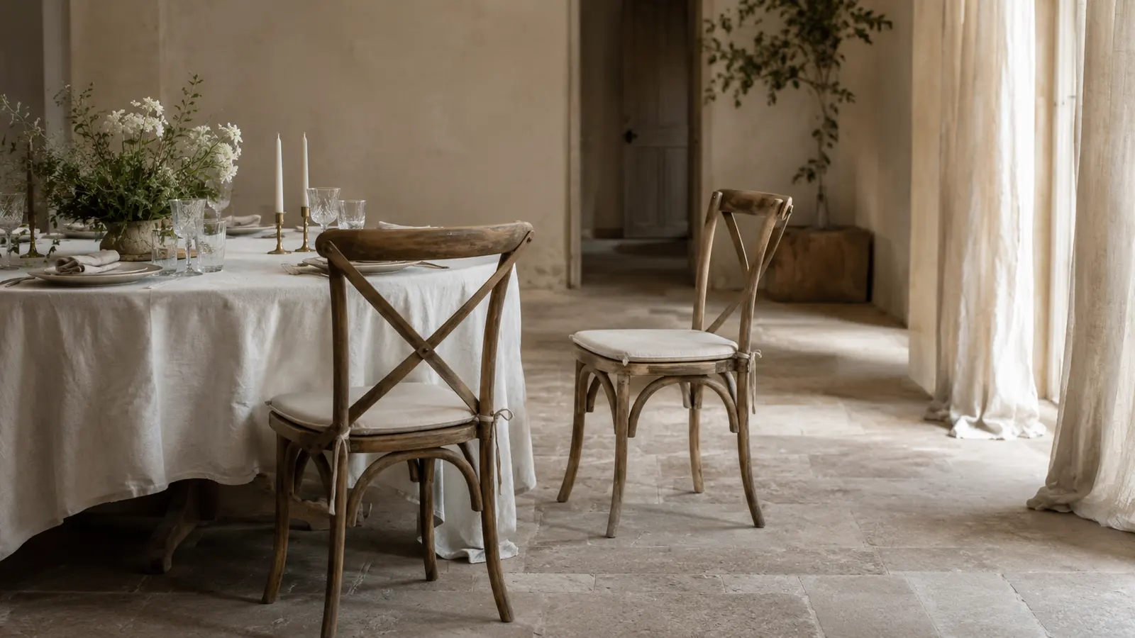 Two chairs at a set table, one pulled slightly back