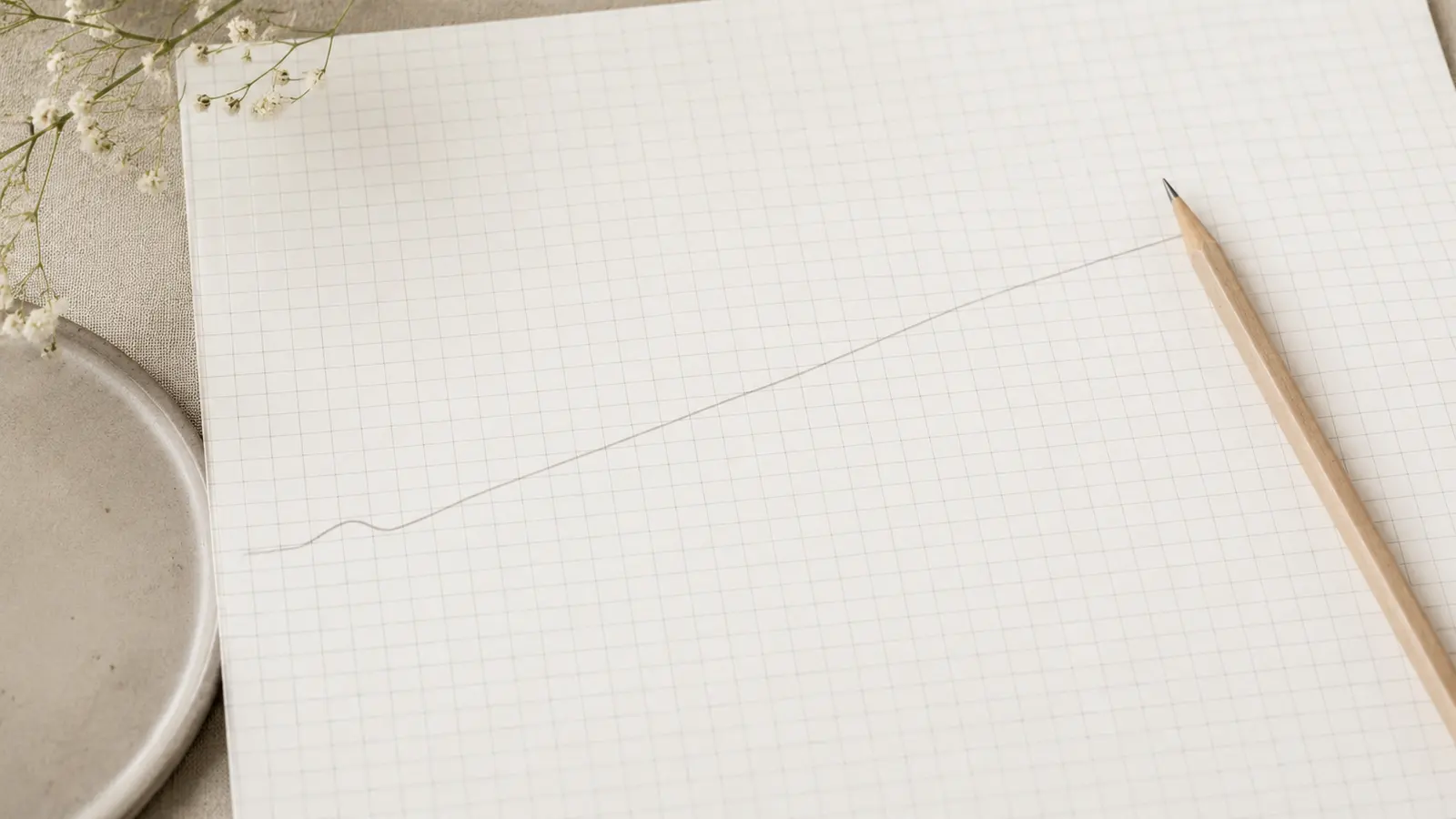 A hand-drawn line rising across squared notebook paper